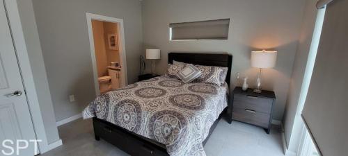 a bedroom with a bed and a night stand with a lamp at New Waterfront Bungalow - Fishermans Paradise - Bungalow Tarvana in South Padre Island