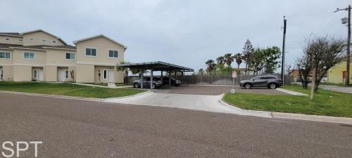 a parking lot next to a house with a carport at New Waterfront Bungalow - Fishermans Paradise - Bungalow Tarvana in South Padre Island