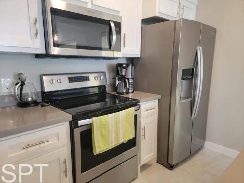 a kitchen with a stove and a stainless steel refrigerator at New Waterfront Bungalow - Fishermans Paradise - Bungalow Tarvana in South Padre Island