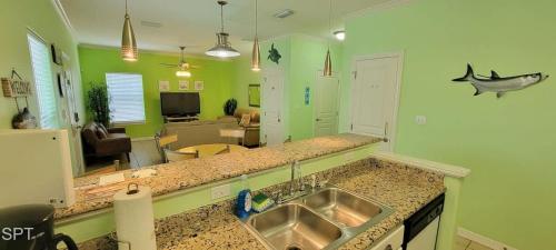 a kitchen with a sink and a living room at Los Cabos I #5 condo in South Padre Island