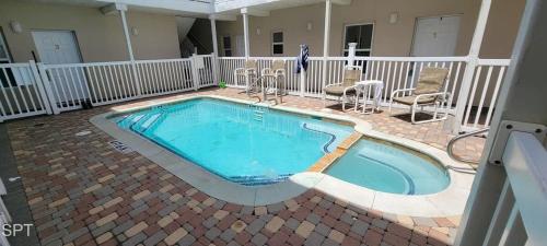 a large swimming pool in a yard with chairs at Los Cabos I #5 condo in South Padre Island
