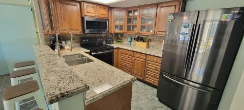 a kitchen with wooden cabinets and a stainless steel refrigerator at Saida Royale 9018 condo in South Padre Island