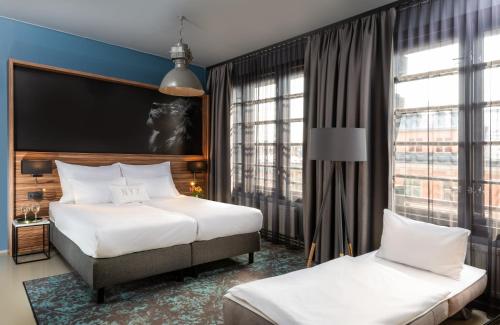 a hotel room with two beds and a large window at NYX Hotel Prague by Leonardo Hotels in Prague