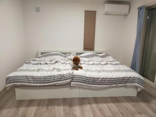 a small teddy bear sitting on a bed at Seaside House Cozy - Vacation STAY 03320v in Sammu