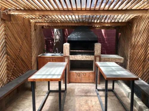 an outdoor kitchen with two benches and a stove at Habitación frente a Muelle Vergara en un departamento in Viña del Mar