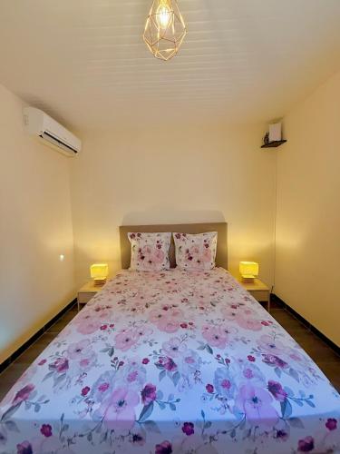 a bedroom with a large bed with pink flowers on it at Villa LUGNA piscine privée in Le Vauclin