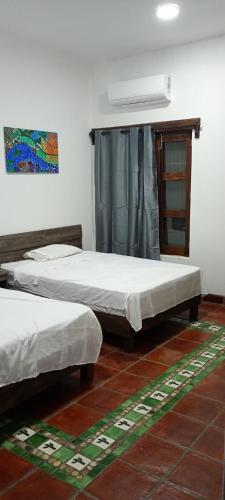 a bedroom with two beds and a fan on the wall at Casa Horizonte in Puerto Escondido