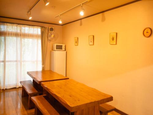a kitchen with a wooden table and a refrigerator at Akane-yado in Nakafurano