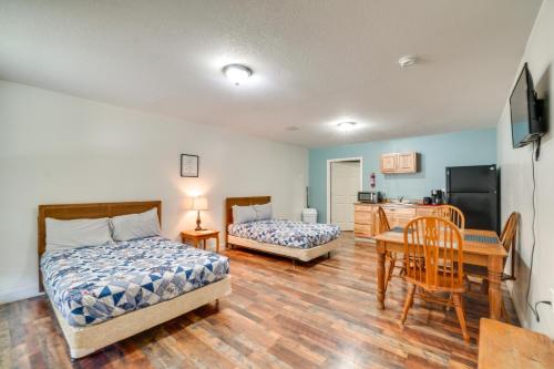 a bedroom with two beds and a table and a kitchen at ATV Trails and River Access Briceville Retreat in Briceville