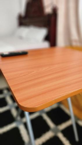 a wooden table with a laptop on top of it at Pulse Kampala living in Kampala