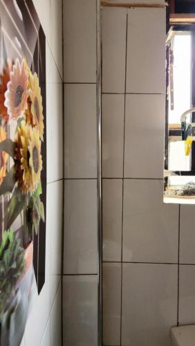 a bathroom with a painting of flowers on the wall at Pulse Kampala living in Kampala