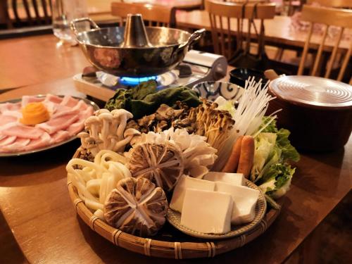 a plate of food on a wooden table at Guesthouse HOALOHA 4 SEASONS in Chino
