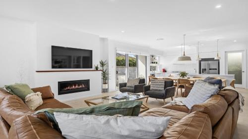 a living room with a couch and a fireplace at Que Syrah in Pokolbin