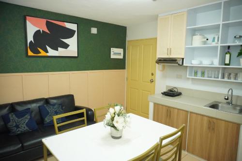 a kitchen with a table and a sink and a table and chairs at Fabulous Condo Suite One Spatial Tower2 in Iloilo City