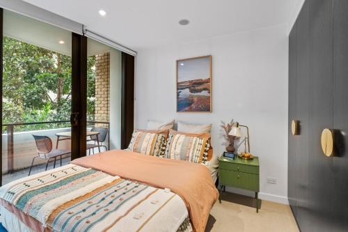 a bedroom with a bed and a balcony at Grand Prix Elite Apartment in Melbourne