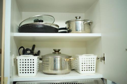 two pots and pans on shelves in a kitchen at Fabulous Condo Suite One Spatial Tower2 in Iloilo City