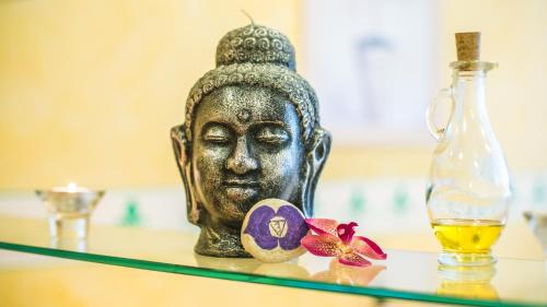 a buddha statue on a glass table with a bottle at EUROPÄISCHER HOF Bad Gastein in Bad Gastein