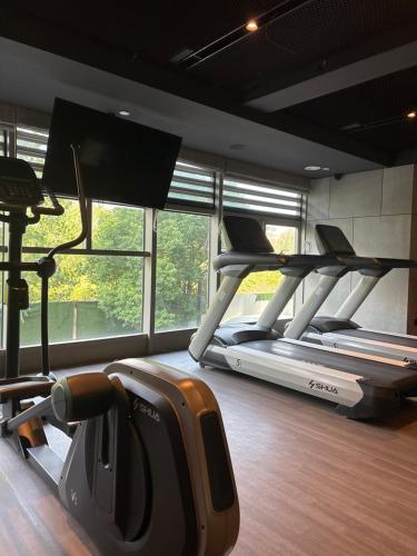 a gym with three treadmill machines in a room with windows at Wanda Grand Hotel, Nanjing South Railway Station in Nanjing