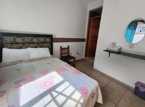 a bedroom with a bed and a mirror on the wall at Casa del Patrón Posada in Taxco de Alarcón