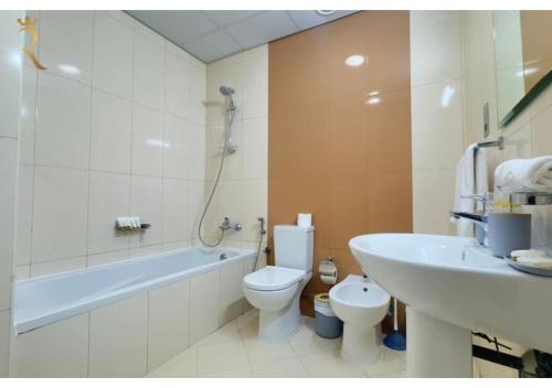 a bathroom with a tub and a toilet and a sink at Stylish Hydra Studio -Serene City Escape in Abu Dhabi