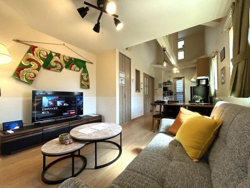 a living room with a couch and a tv at 新大阪旅庵 民泊縁家 in Osaka