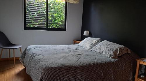 a bedroom with a bed and a window at Valdivia, Cabañas camino a Niebla in Valdivia