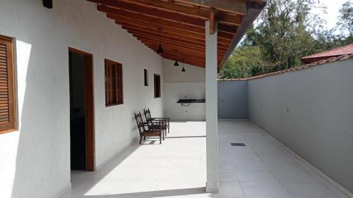 a porch of a house with chairs and a table at Lofts mahalo in Ubatuba