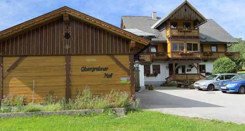 ein Holzgebäude mit einem Schild an der Seite in der Unterkunft Obergrabnerhof in Ramsau am Dachstein