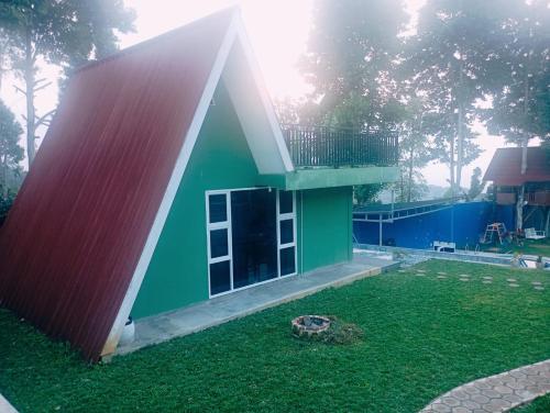 a small house with a red and green roof at villa omah citeko 2 in Tagalbato