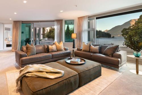 a living room with couches and a large window at Q1 Luxury Central Apartment in Queenstown
