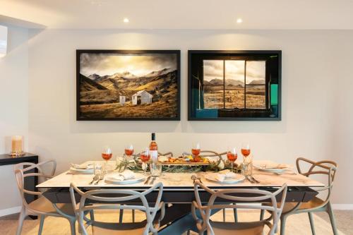 a dining room with a table with glasses of wine at Q1 Luxury Central Apartment in Queenstown
