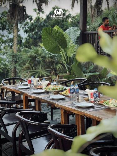 a wooden table with plates of food on it at Cọ Retreat Da Bac in Hòa Bình