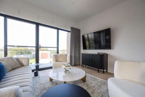 a living room with a couch and a tv at Surf House Cape - Cape Paterson in Cape Paterson