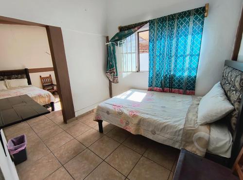 a small room with a bed and a window at Casa del Patrón Posada in Taxco de Alarcón