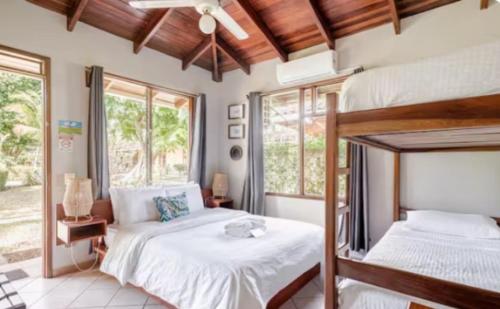 a bedroom with two bunk beds and two windows at Hotel Bahia Esmeralda in Potrero