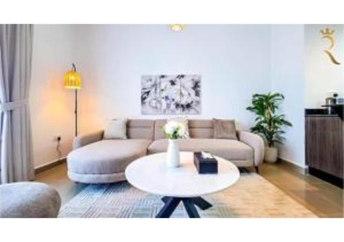 a living room with a couch and a table at Reef Edge 1BR - Elegant Coastal Getaway in Abu Dhabi