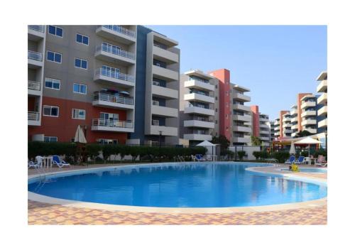 an empty swimming pool in front of some apartment buildings at Reef Edge 1BR - Elegant Coastal Getaway in Abu Dhabi