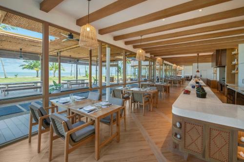 a restaurant with tables and chairs and a pool at Marriott Vacation Club, Khao Lak Beach Resort in Khao Lak