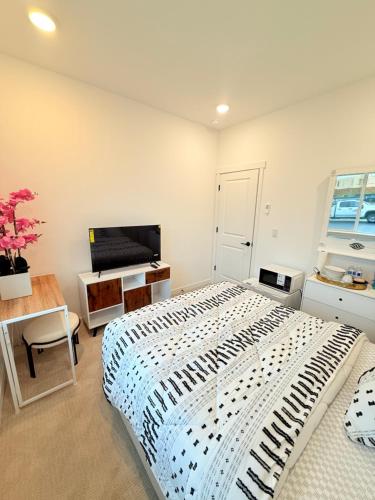 a bedroom with a large bed and a television at Cozy Private Room, Room 1, Near Seattle and Mt Rainier, Quiet and Comfy Stay in Bonney Lake
