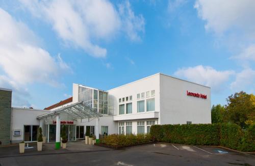 a white building with a sign on it at Leonardo Hotel Heidelberg in Heidelberg