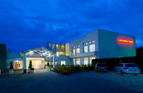 a building with a car parked in a parking lot at Leonardo Hotel Heidelberg in Heidelberg