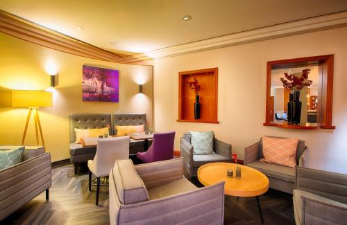 a living room with couches and a dining room at Leonardo Hotel Heidelberg in Heidelberg