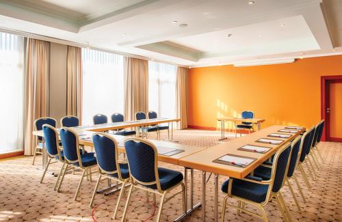 a conference room with a long table and chairs at Leonardo Hotel Heidelberg in Heidelberg