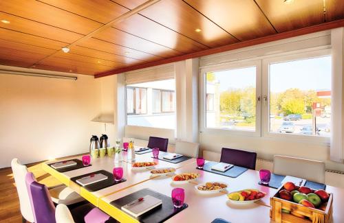 a dining room with a table and chairs with food on it at Leonardo Hotel Heidelberg in Heidelberg