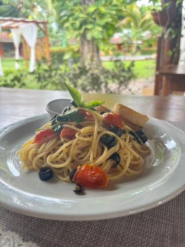 a plate of pasta with vegetables on a table at Hotel Bahia Esmeralda in Potrero