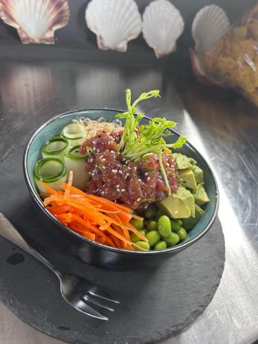 a bowl of food with meat and vegetables on a table at Hotel Bahia Esmeralda in Potrero