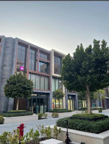 ein Gebäude mit einem Baum davor in der Unterkunft استوديو فاخر مفروش في الشارقة الزاهية in Sabkhah