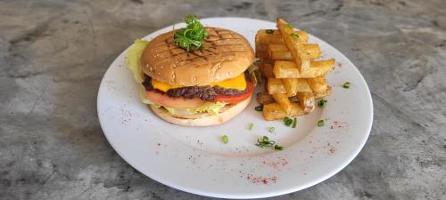 a hamburger and french fries on a plate at Mystic Paracas Hotel & Glampings in Paracas