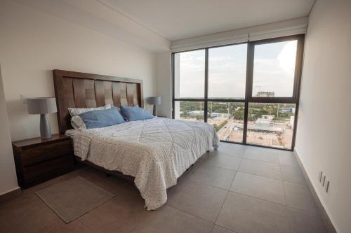 a bedroom with a bed and a large window at Indico in Mérida