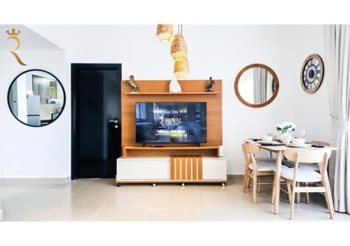 a living room with a tv and a table at Elegant 1BR - Al Reef Urban Haven in Abu Dhabi